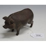 An early/mid-20th Century cast bronze desk bell in the form of a pig with amber and black eyes,