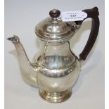 A silver coffee pot of baluster form, with a stained hardwood handle and finial and shell cast