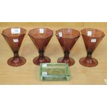 Four amethyst glass wines, circa 1900, each flared octagonal bowl raised on a spreading circular