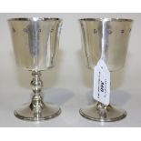 A pair of silver goblets, each with flared bucket bowl and turned baluster stem on a circular