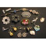 An oval brooch in a floral design, twelve further mostly silver brooches, a small fob seal, three