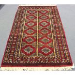 A Pakistan rug, late 20th Century, the red field with overall offset rows of guls, within a