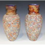 A pair of Doulton Lambeth Slaters Patent stoneware vases, of elongated ovoid form with flared necks,
