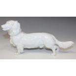 A Meissen white glazed porcelain model of a long haired dachshund, 20th Century, crossed swords in