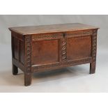 An early 18th Century oak coffer, the hinged lid with a moulded edge above a double panelled front