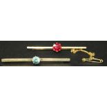 A gold and blue zircon set single stone bar brooch, width approx 5.5cm, and a gold and red gem set