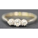 A gold, platinum and diamond three stone ring, claw set with a row of cushion shaped diamonds,