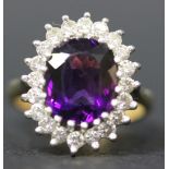 A gold, amethyst and diamond ring, claw set with the amethyst within a surround of circular cut