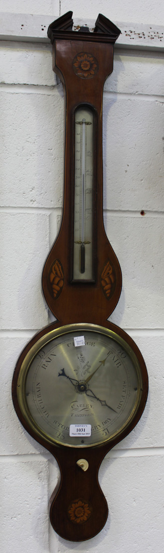 An early 19th Century mahogany wheel barometer with alcohol thermometer and silvered dials,