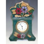 An Art Nouveau pottery mantel timepiece, the dial with Arabic numerals, the case painted with