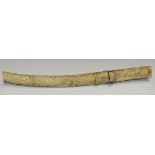 A Japanese carved bone tanto with curved single edged blade, length approx 22cm, the grip with