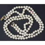 A two row necklace of uniform cultured pearls, on a 9ct gold and diamond set triple section clasp,