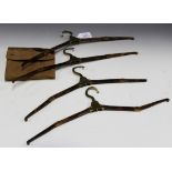 A set of four early 20th Century tortoiseshell effect and gilt brass folding travel clothes hangers,