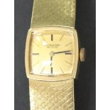 An International Watch Co 18ct gold lady's bracelet wristwatch, the signed square dial with black