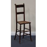 An early Victorian beech framed child's chair with a carved double bar back above a caned seat, on