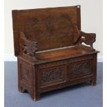 A late Victorian oak monk's bench, the hinged lid on carved lion supports, the box seat base with