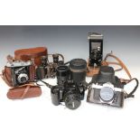 A collection of assorted cameras and accessories, including a Canon EOS 3000 camera with 50mm