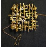 A gold and diamond brooch, cast and pierced in an abstract modern design, claw set with five