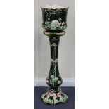 An Art Nouveau Continental majolica jardinière and stand, the jardinière moulded with swans, lily