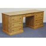 A modern oak twin pedestal desk, fitted with seven drawers, on plinth bases, height approx 76cm,
