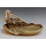 An Art Nouveau Royal Dux porcelain centrepiece bowl, modelled as a recumbent maiden musician resting