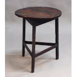 A George III oak circular cricket table, on block legs united by stretchers, height approx 66.5cm,