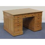 A Victorian stripped pine twin pedestal desk, fitted with nine drawers and two cupboards, on