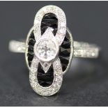 A diamond and black onyx set ring in a shaped oval panel shaped design, mounted with the principle