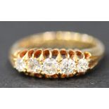 A gold and diamond five stone ring, claw set with a row of cushion shaped diamonds graduating in