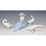A group of three Lladro figures of geese and a Lladro Nao figure of a girl.