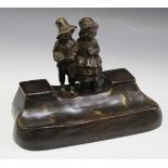 R. Bahnert - an early 20th Century brown patinated cast bronze inkstand, the shaped base with a