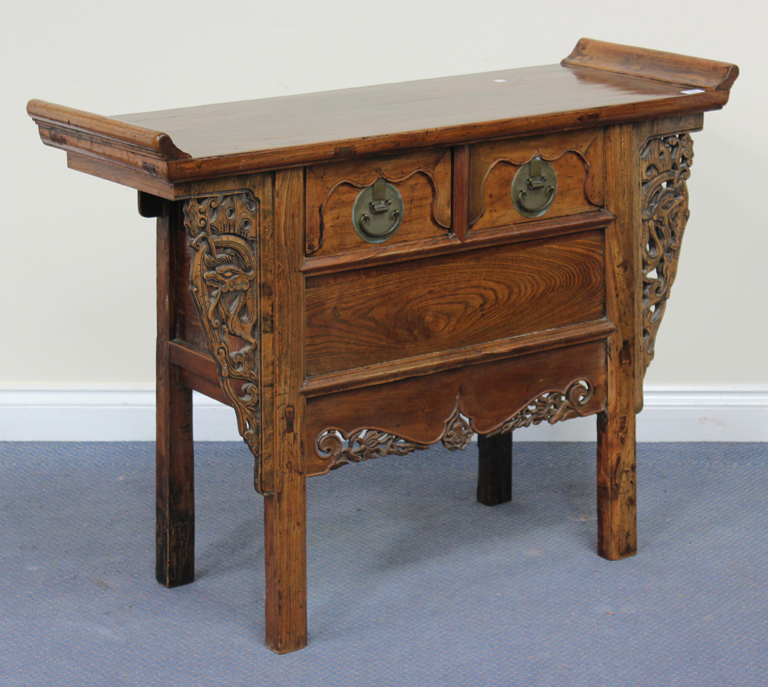A 20th Century Chinese elm side table with a shaped rectangular top above two frieze drawers and