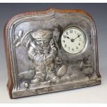 An early 20th Century plate mounted oak mantel timepiece, the cream dial with Arabic numerals, the