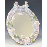 A Dresden porcelain oval dressing table mirror, late 19th Century, the flower encrusted frame