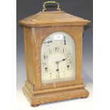 An early 20th Century German oak mantel clock with eight day movement striking on gongs, the