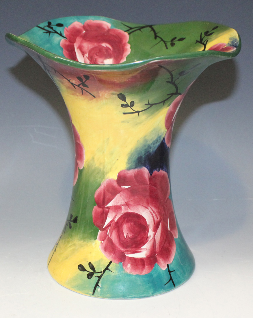 A Wemyss pottery jazzy ware trumpet vase, painted with cabbage rose on a colourful ground,