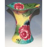 A Wemyss pottery jazzy ware trumpet vase, painted with cabbage rose on a colourful ground,