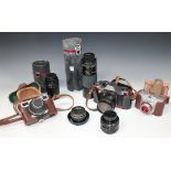 A small group of cameras and lenses, including a Praktica PL Noval camera with auto Chinon 1:2.8 F=