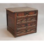 A late 17th Century oak chest of small proportions, the hinged top above three long drawers with