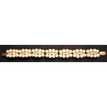 A gold and cultured pearl bracelet, formed as a row of curved panel shaped links mounted with rows