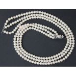 A three row necklace of uniform cultured pearls, on a 9ct white gold, diamond and cultured pearl set