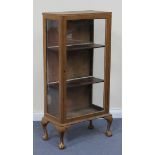 An early 20th Century gilt painted display cabinet, fitted with a single glazed door, on cabriole