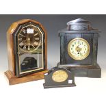 A late 19th Century German walnut mantel timepiece, the black dial with gilt Roman numerals, the