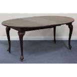A George V mahogany extending dining table, fitted with an extra leaf, raised on cabriole legs and