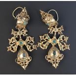 A pair of gold and foil backed emerald set pendant earrings, each of quadruple sectioned form with