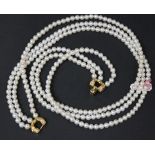 A three row necklace of uniform cultured pearls, on a 9ct gold, sapphire and diamond set triple