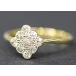 A gold and platinum, diamond set nine stone cluster ring in a lozenge shaped design, mounted with