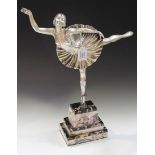 An Art Deco style silvered cast metal figure of a ballerina standing on one leg, bearing 'Made in