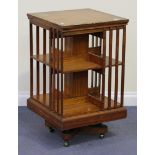 A late Victorian satinwood revolving bookcase, probably by 'Maple and Co', the top crossbanded and