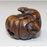 A Japanese carved hardwood netsuke, probably 20th Century, formed as two rats on and within a